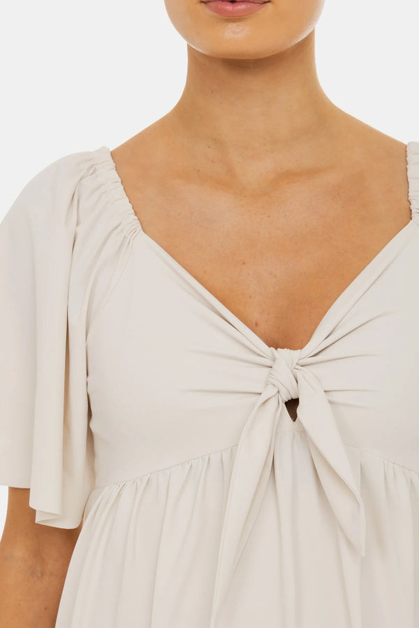 Φόρεμα εγκυμοσύνης με σούρες και φιόγκο – σε ανοιχτό μπεζ - - soonMAMA - Η σωστή προσθήκη στην κομψή και άνετη εγκυμοσύνη! - Παλτά για έγκυες